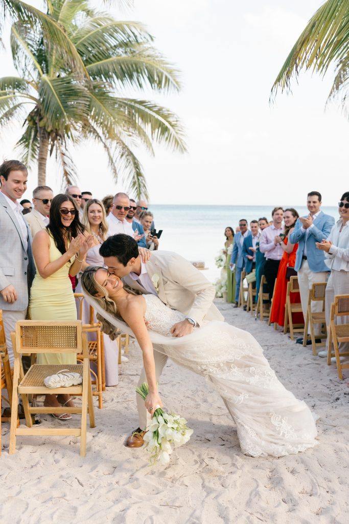 Destination wedding couple kissing on beach at sunset Riviera Maya Mexico