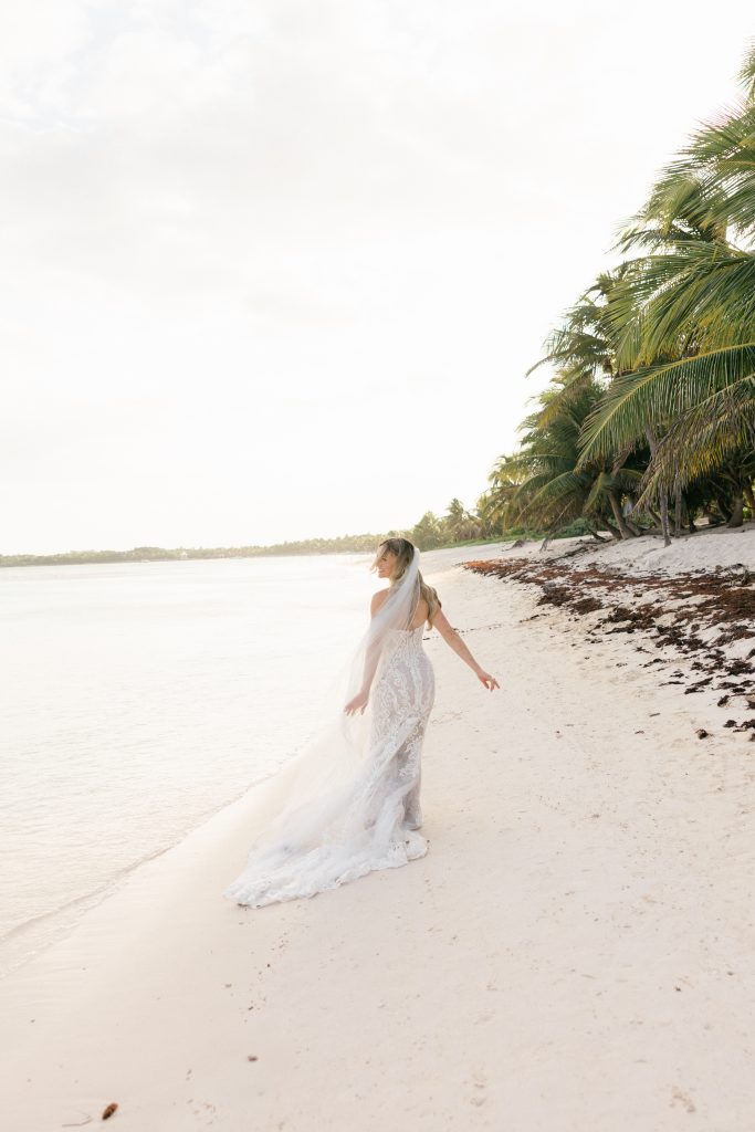 Barefoot bride walking on white sand Kantenah beach Caribbean Mexico