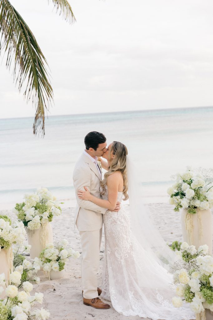 Destination wedding couple kissing on beach at sunset Riviera Maya Mexico