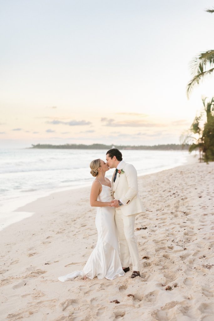 Couple walking on Tulum beach at sunset, captured by a destination wedding photographer in Tulum, Mexico.