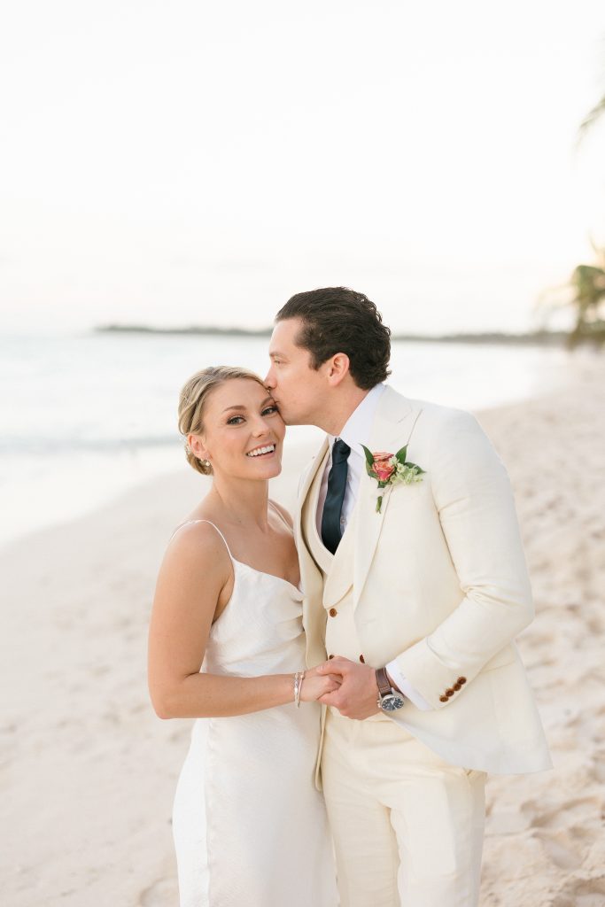 Couple walking on Tulum beach at sunset, captured by a destination wedding photographer in Tulum, Mexico.