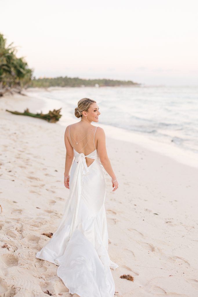 Couple walking on Tulum beach at sunset, captured by a destination wedding photographer in Tulum, Mexico.