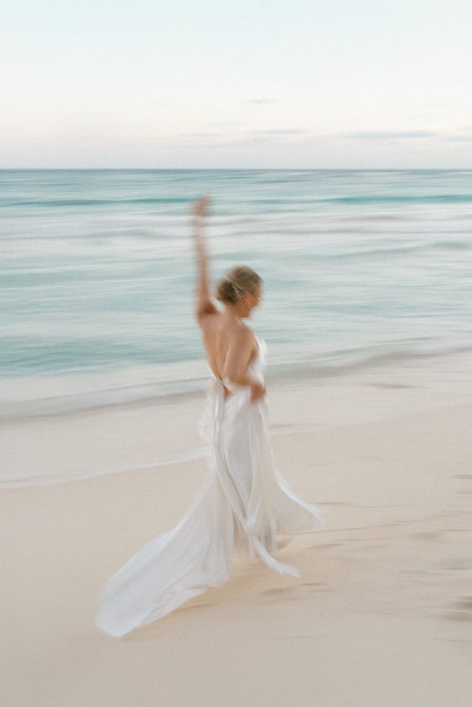 Couple walking on Tulum beach at sunset, captured by a destination wedding photographer in Tulum, Mexico.