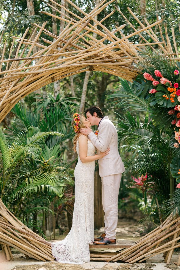 First kiss under the bamboo arch at Espacio Chechén, Tulum jungle wedding
